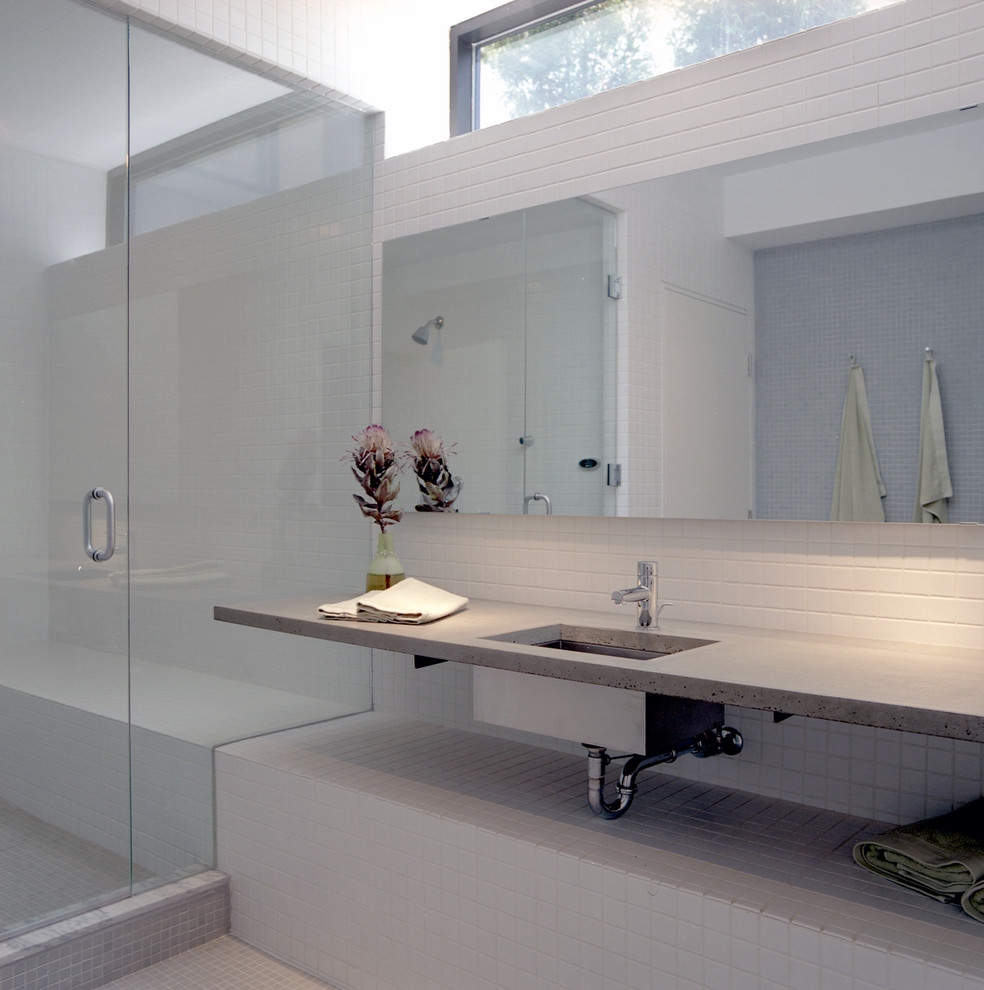 Inspiration for a large modern master bathroom in Los Angeles with an undermount sink, concrete benchtops, white tile, white walls, an alcove shower, a two-piece toilet, mosaic tile floors, ceramic tile, beige floor, a hinged shower door, open cabinets, white cabinets and grey benchtops.
