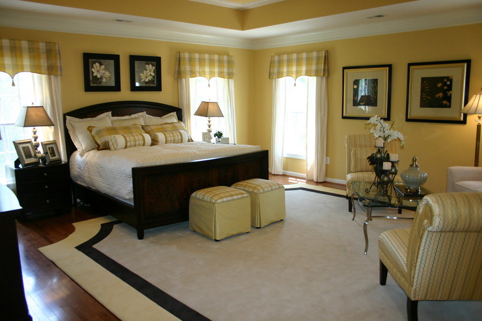 Traditional master bedroom in Baltimore with yellow walls, dark hardwood floors and no fireplace.