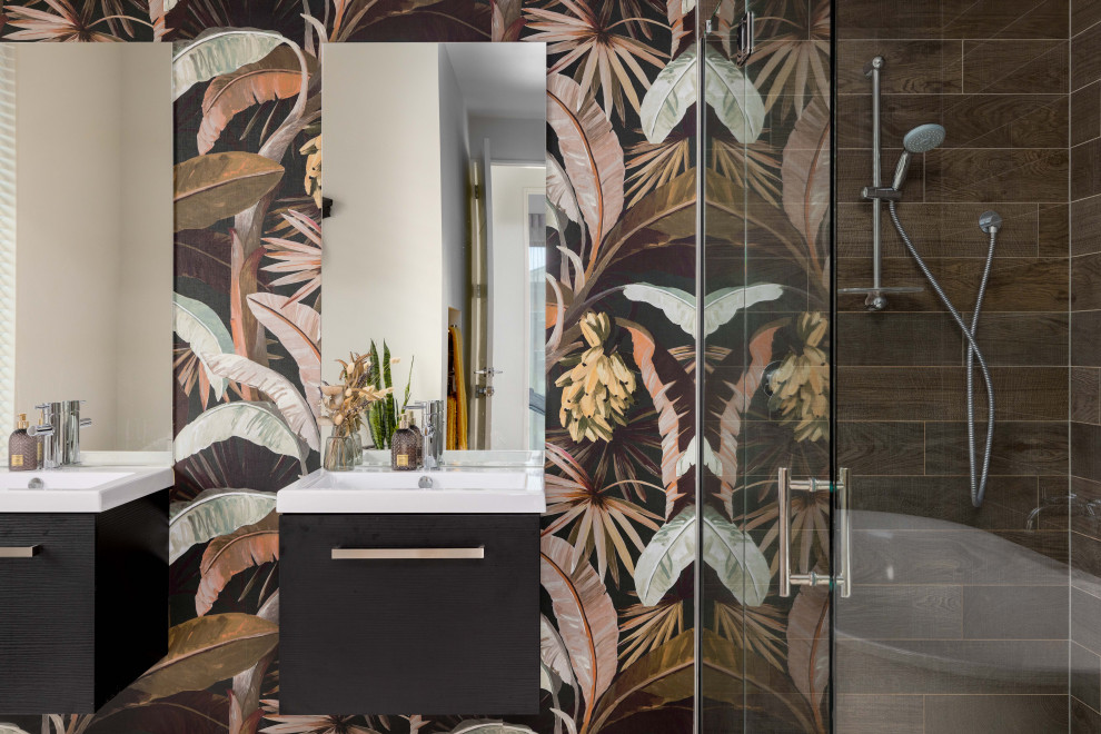 Mittelgroße Gästetoilette mit braunen Schränken, farbigen Fliesen, bunten Wänden, weißer Waschtischplatte, schwebendem Waschtisch und Tapetenwänden in Christchurch