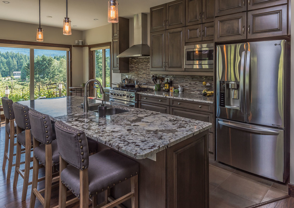 Example of a transitional open concept kitchen design in Toronto with a double-bowl sink, raised-panel cabinets, dark wood cabinets, marble countertops, multicolored backsplash, matchstick tile backsplash, stainless steel appliances and an island