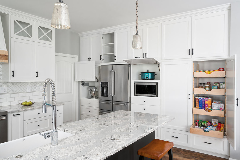 Expansive transitional kitchen in Columbus with a farmhouse sink, shaker cabinets, white cabinets, quartz benchtops, white splashback, stainless steel appliances, with island, subway tile splashback and multi-coloured benchtop.