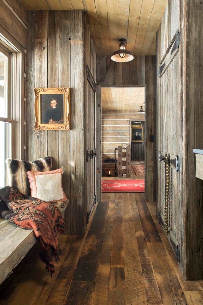 Inspiration for a mid-sized country hallway in Denver with brown walls and dark hardwood floors.