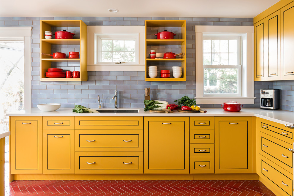 Photo of a contemporary l-shaped kitchen in Boston with an undermount sink, yellow cabinets, blue splashback, flat-panel cabinets, stainless steel appliances and with island.