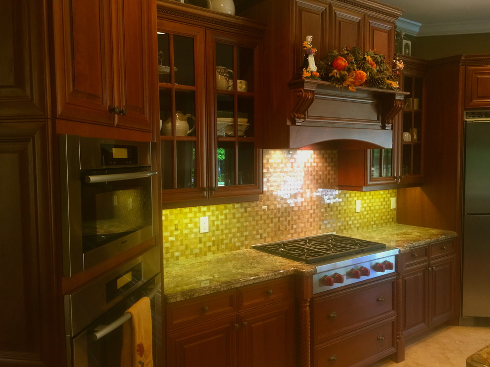 Small elegant eat-in kitchen photo with raised-panel cabinets, dark wood cabinets, yellow backsplash and mosaic tile backsplash