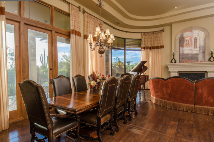 Huge transitional formal and open concept dark wood floor dining room photo in Phoenix with yellow walls, a standard fireplace, a stone fireplace and no tv