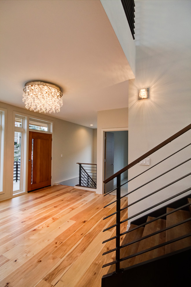 Inspiration for a large contemporary foyer in Seattle with beige walls, light hardwood floors, a single front door, a dark wood front door and beige floor.