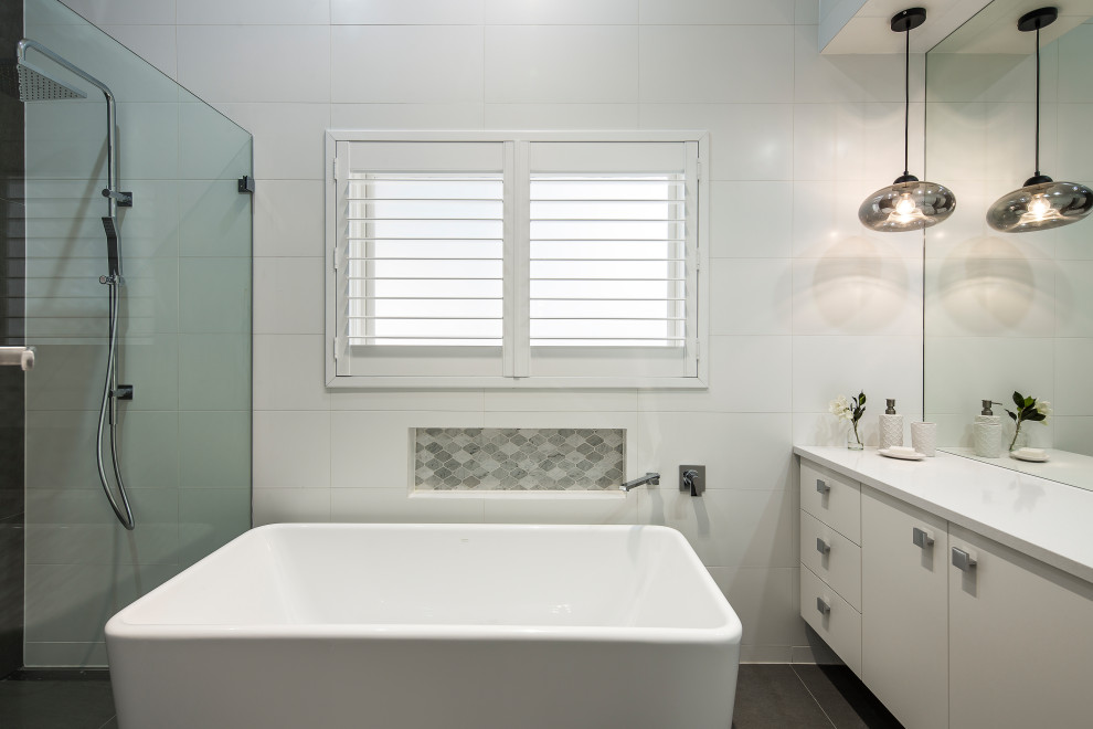 Inspiration for a mid-sized modern master bathroom in Adelaide with white cabinets, an alcove shower, white tile, porcelain tile, white walls, porcelain floors, a vessel sink, engineered quartz benchtops, grey floor, a hinged shower door, white benchtops, a niche, a single vanity and a floating vanity.