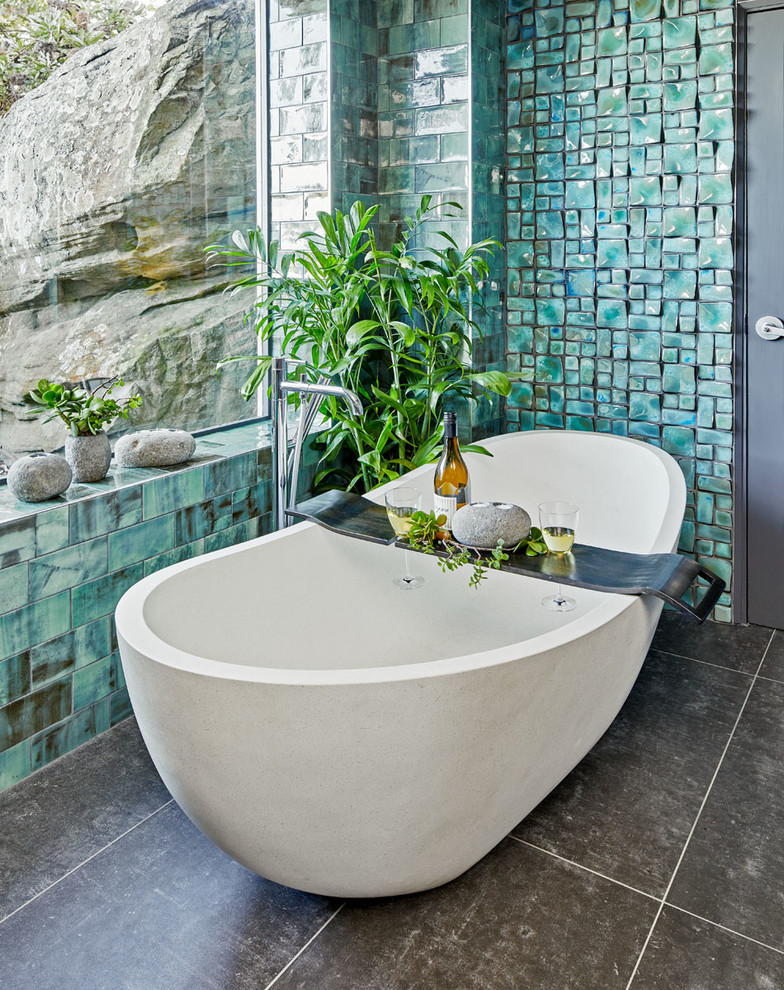 Photo of a large contemporary master wet room bathroom in Sydney with furniture-like cabinets, medium wood cabinets, a freestanding tub, gray tile, porcelain tile, green walls, porcelain floors, a vessel sink, wood benchtops, grey floor and an open shower.