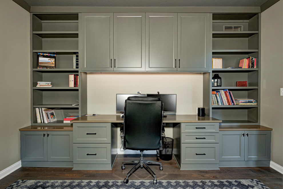 Photo of a mid-sized contemporary home office in Indianapolis with beige walls, dark hardwood floors, recessed, a built-in desk and brown floor.