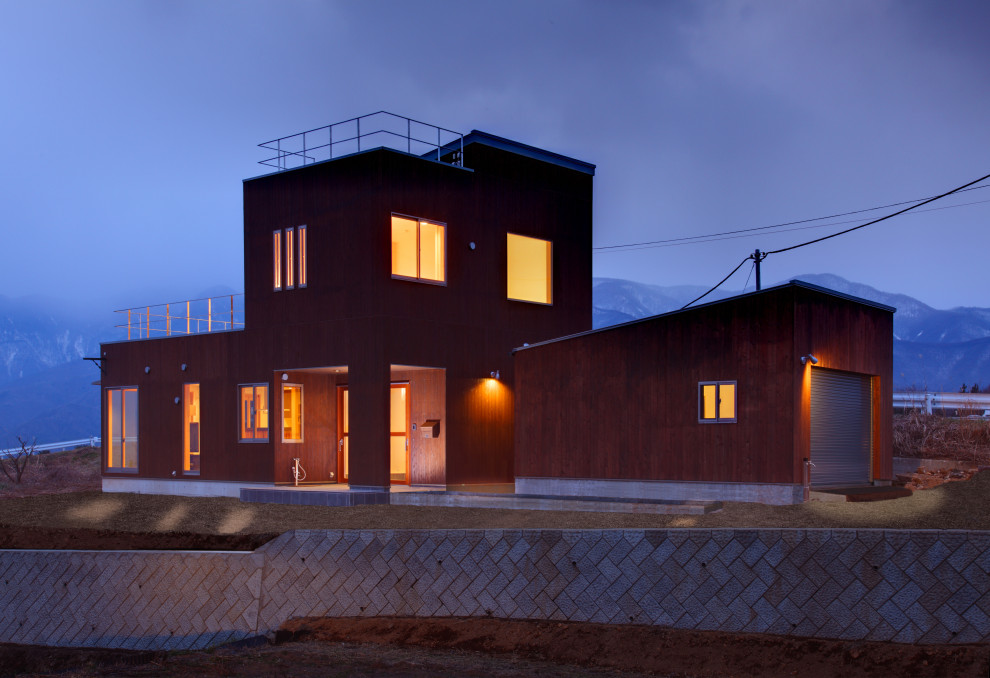 Mittelgroßes, Zweistöckiges Modernes Haus mit brauner Fassadenfarbe, Flachdach, Blechdach, grauem Dach und Wandpaneelen in Sonstige