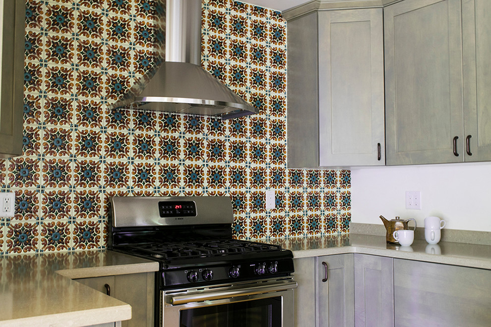 Mid-sized transitional l-shaped light wood floor and beige floor eat-in kitchen photo in Phoenix with an undermount sink, shaker cabinets, gray cabinets, granite countertops, multicolored backsplash, ceramic backsplash, stainless steel appliances and an island