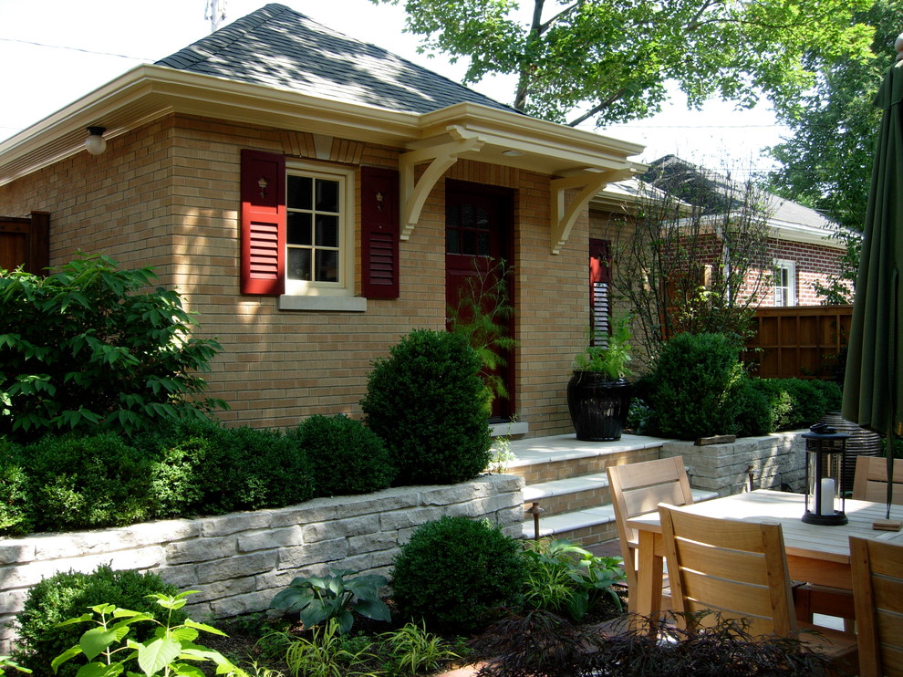 Photo of a small traditional one-storey brick brown house exterior in Chicago with a hip roof and a shingle roof.