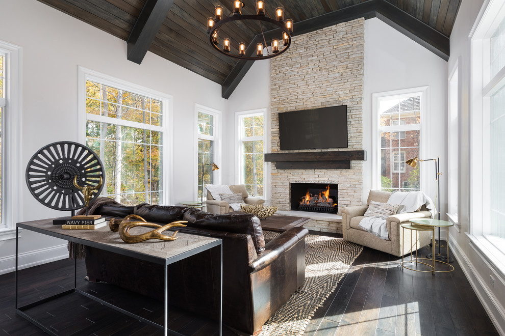This is an example of a large transitional enclosed living room in Chicago with dark hardwood floors, a standard fireplace, a stone fireplace surround, white walls and a wall-mounted tv.