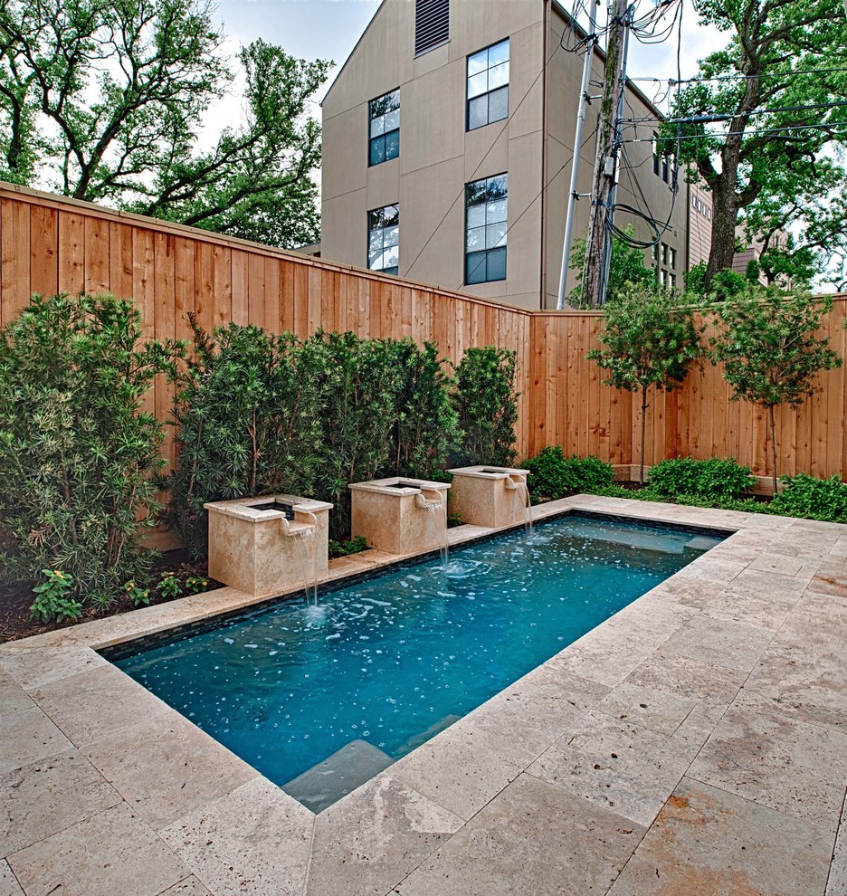 Photo of a small contemporary backyard rectangular pool in Houston with a water feature and natural stone pavers.
