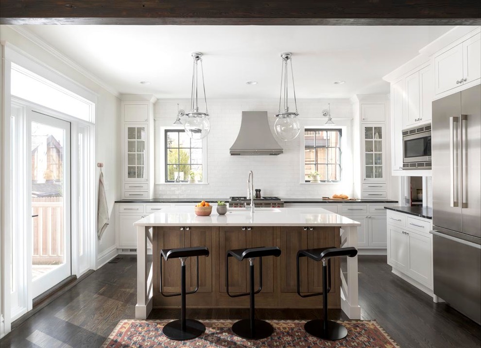 Mid-sized transitional l-shaped dark wood floor kitchen pantry photo in Denver with an undermount sink, recessed-panel cabinets, white cabinets, white backsplash, stainless steel appliances and an island