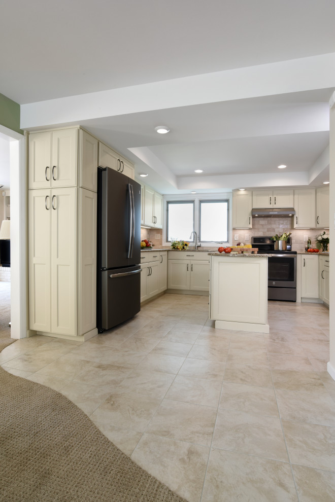 Enclosed kitchen - mid-sized transitional u-shaped porcelain tile, beige floor and tray ceiling enclosed kitchen idea with an undermount sink, flat-panel cabinets, beige cabinets, quartz countertops, beige backsplash, travertine backsplash, black appliances, an island and beige countertops