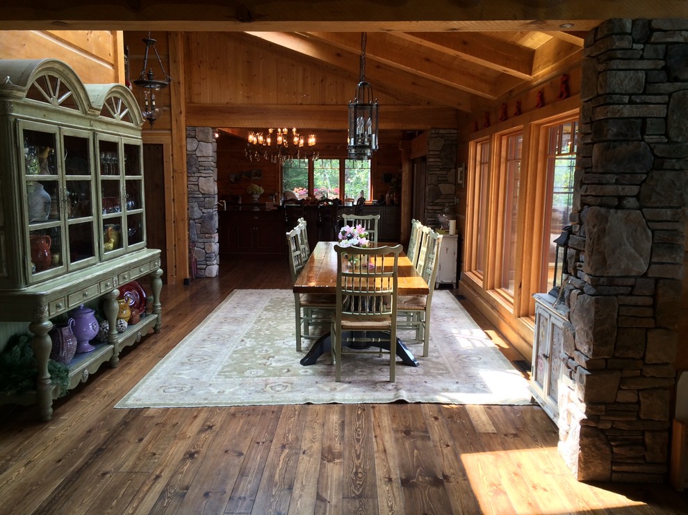 Photo of a mid-sized country open plan dining in Other with brown walls, medium hardwood floors, no fireplace and brown floor.
