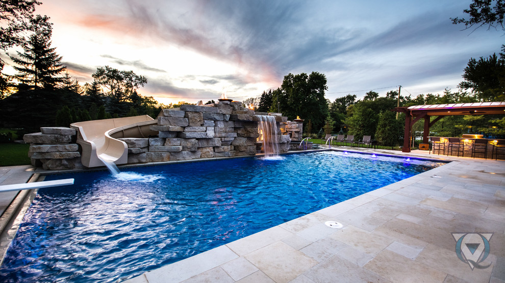 Large mountain style backyard stone and rectangular natural pool fountain photo in Chicago