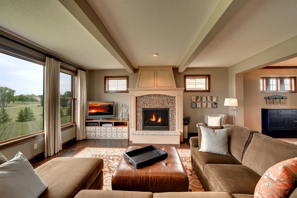 Traditional open concept family room in Minneapolis with beige walls, dark hardwood floors, a standard fireplace, a tile fireplace surround and a freestanding tv.