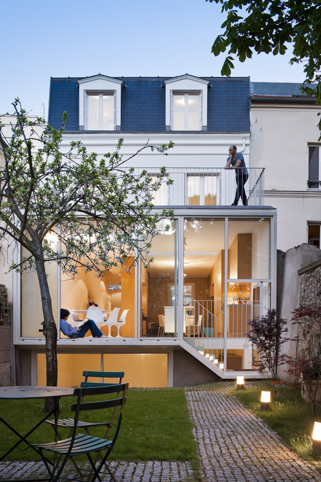 Photo of a large contemporary two-storey glass white exterior in Paris with a hip roof.