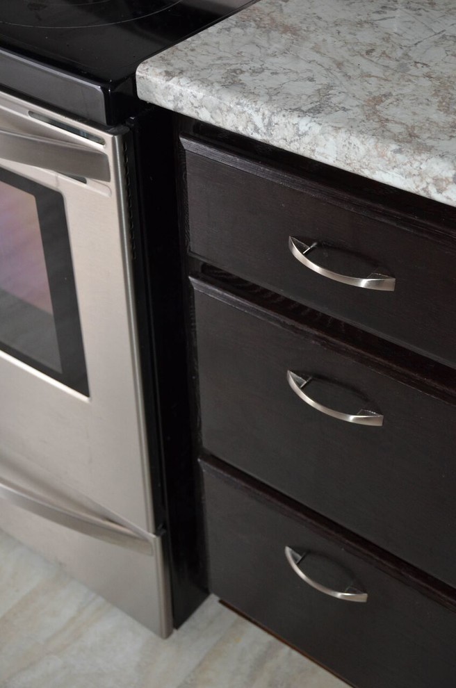 Example of a small transitional galley vinyl floor and gray floor enclosed kitchen design with a drop-in sink, recessed-panel cabinets, dark wood cabinets, laminate countertops, glass tile backsplash, stainless steel appliances and no island