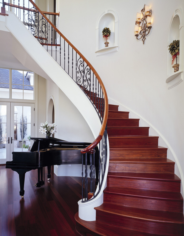 Design ideas for a traditional wood curved staircase in Charleston with wood risers.