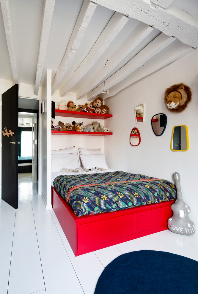 This is an example of a mid-sized scandinavian gender-neutral kids' bedroom for kids 4-10 years old in Paris with white walls and painted wood floors.