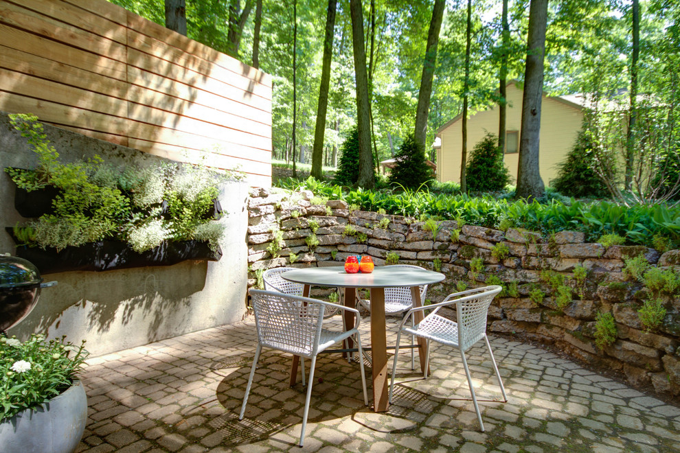 Design ideas for a mid-sized midcentury patio in Grand Rapids with a vertical garden, brick pavers and no cover.