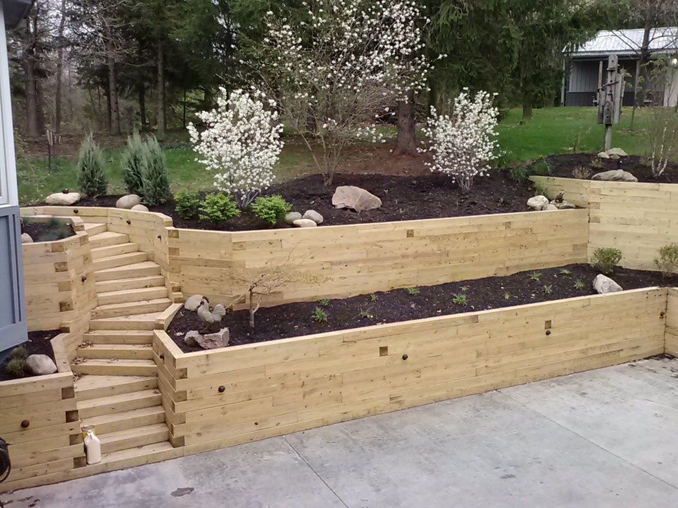 Photo of a large country sloped full sun garden for summer in Columbus with a retaining wall and decking.