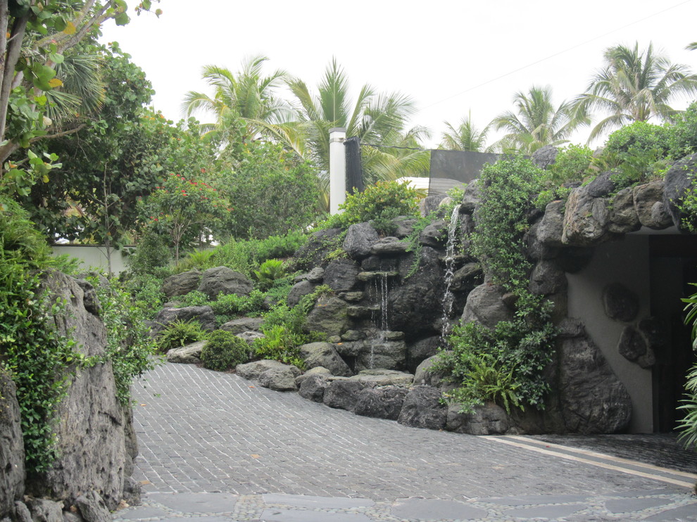 Photo of a mid-sized asian front yard garden in Miami with a water feature and natural stone pavers.