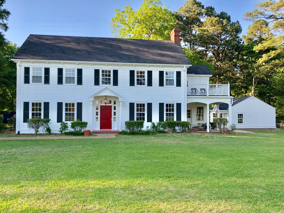 This is an example of a traditional white house exterior in Other with a shingle roof.