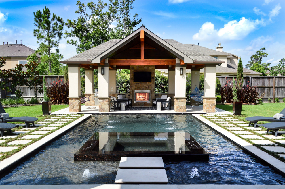 Design ideas for a large traditional backyard custom-shaped pool in Houston with a pool house and natural stone pavers.