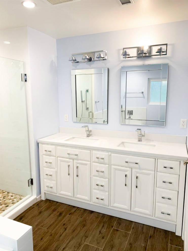 Inspiration for a large transitional master bathroom in Los Angeles with flat-panel cabinets, white cabinets, a corner tub, an alcove shower, white tile, cement tile, purple walls, medium hardwood floors, marble benchtops, brown floor, a hinged shower door, white benchtops and a double vanity.