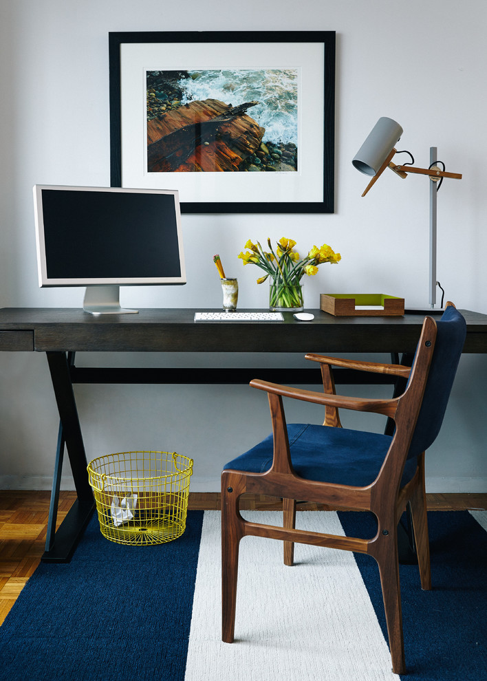 Photo of a midcentury home office in New York with white walls and a freestanding desk.