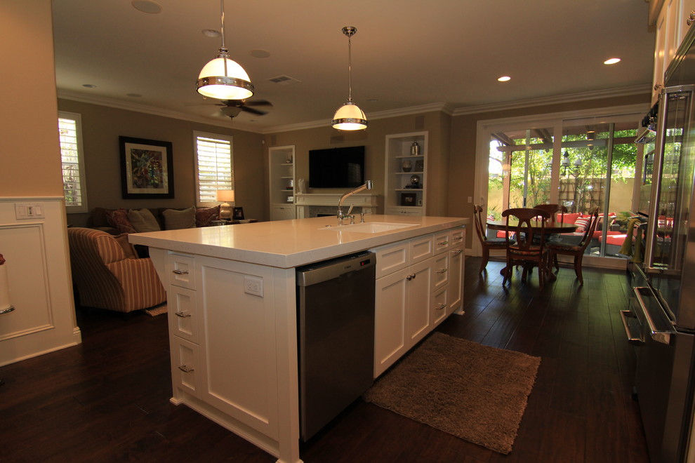 Example of a transitional l-shaped eat-in kitchen design in Orange County with an undermount sink, shaker cabinets, white cabinets, quartz countertops and stainless steel appliances