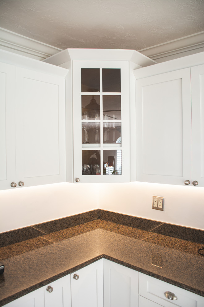 Eat-in kitchen - mid-sized transitional eat-in kitchen idea in Miami with a single-bowl sink, shaker cabinets, white cabinets, granite countertops, black backsplash, granite backsplash, stainless steel appliances, a peninsula and black countertops