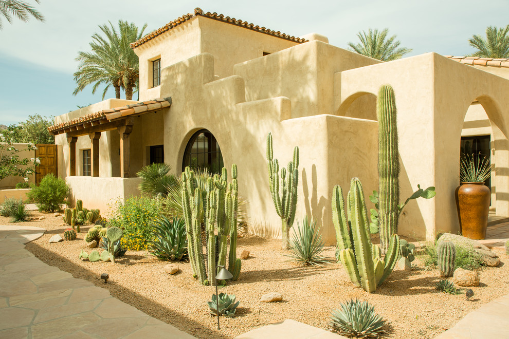 This is an example of an expansive two-storey adobe beige house exterior in Phoenix with a hip roof and a tile roof.