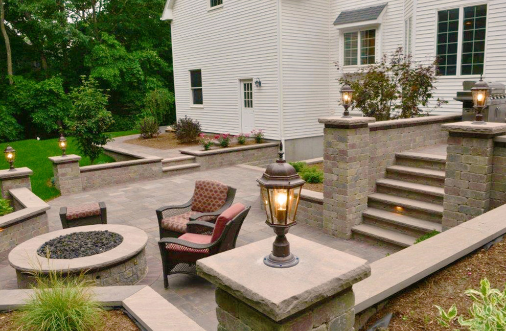 Large contemporary backyard patio in Providence with a fire feature, natural stone pavers and no cover.