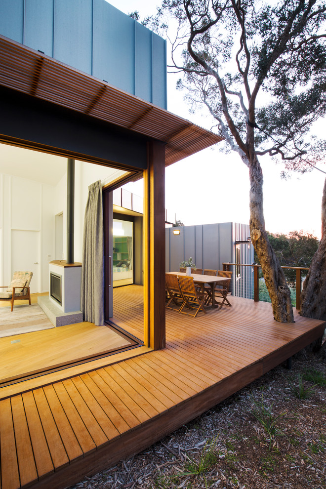 Mid-sized contemporary side yard and ground level deck in Melbourne with no cover and cable railing.