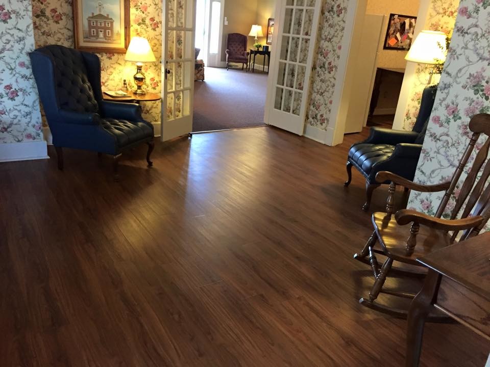 Photo of a mid-sized country enclosed family room in Nashville with multi-coloured walls, dark hardwood floors and brown floor.