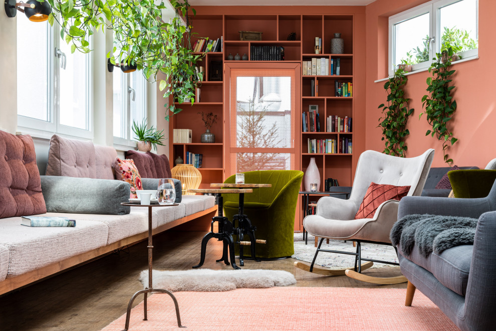 Design ideas for a mid-sized industrial loft-style living room in Other with a library, pink walls, carpet, a wood stove, a metal fireplace surround, a built-in media wall, beige floor, recessed and decorative wall panelling.