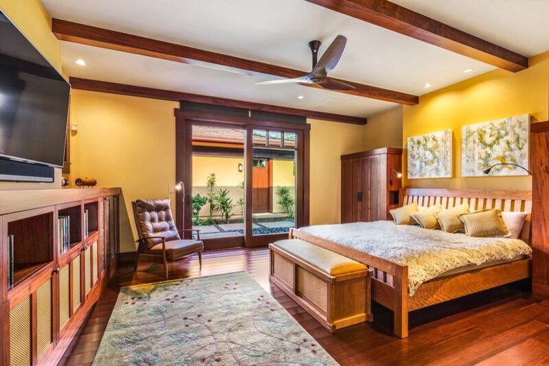 This is an example of a large arts and crafts guest bedroom in Hawaii with orange walls and dark hardwood floors.