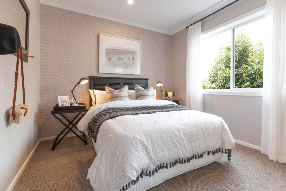 This is an example of a mid-sized beach style guest bedroom in Melbourne with beige walls, carpet, beige floor and wallpaper.