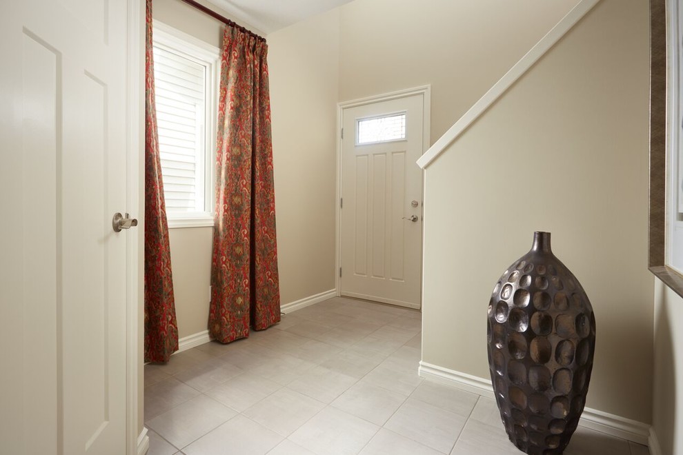 Entry hall - mid-sized transitional ceramic tile and beige floor entry hall idea in Edmonton with white walls and a white front door