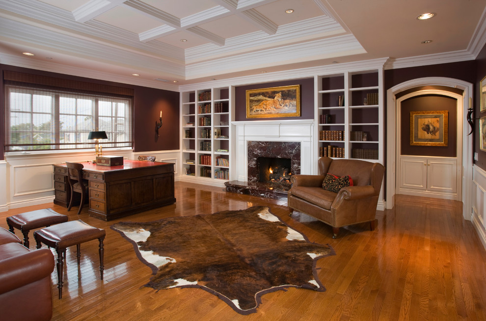 Traditional home office in Orange County with a library, brown walls, medium hardwood floors, a standard fireplace and a stone fireplace surround.