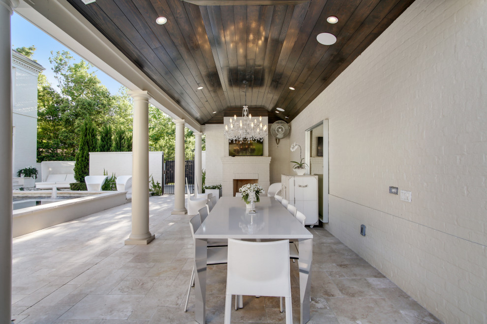 Large transitional backyard verandah in New Orleans with with fireplace, tile and a pergola.