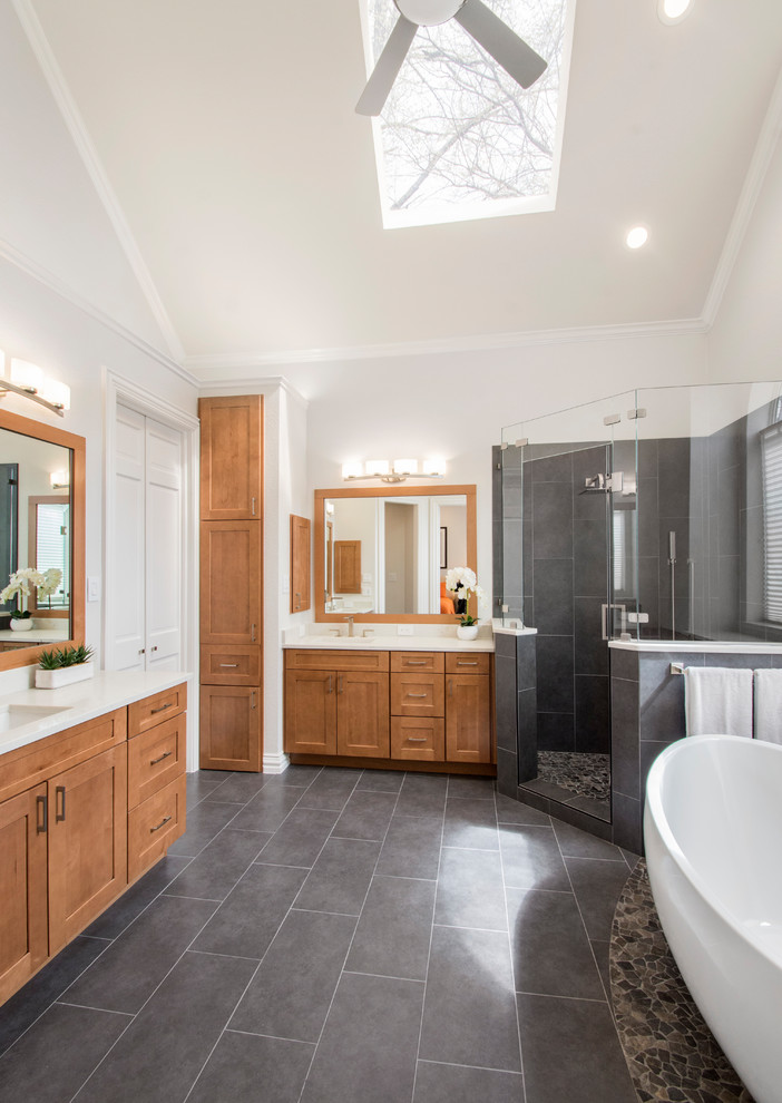 Mid-sized elegant master gray tile and porcelain tile porcelain tile and gray floor freestanding bathtub photo in Dallas with flat-panel cabinets, brown cabinets, a one-piece toilet, gray walls, an undermount sink, quartzite countertops, a hinged shower door and white countertops