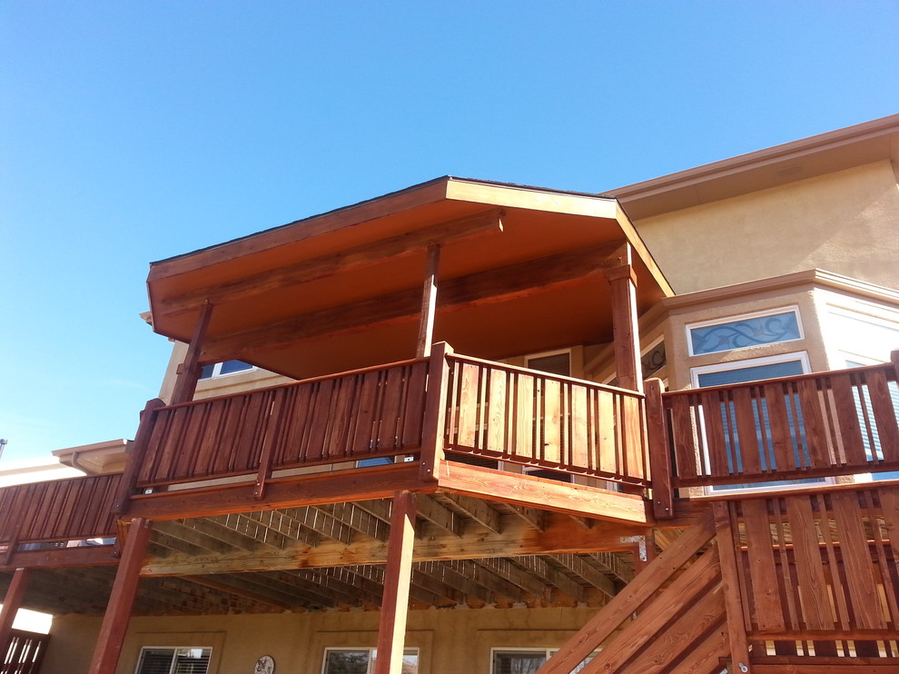 Example of a mid-sized transitional backyard deck design with an awning
