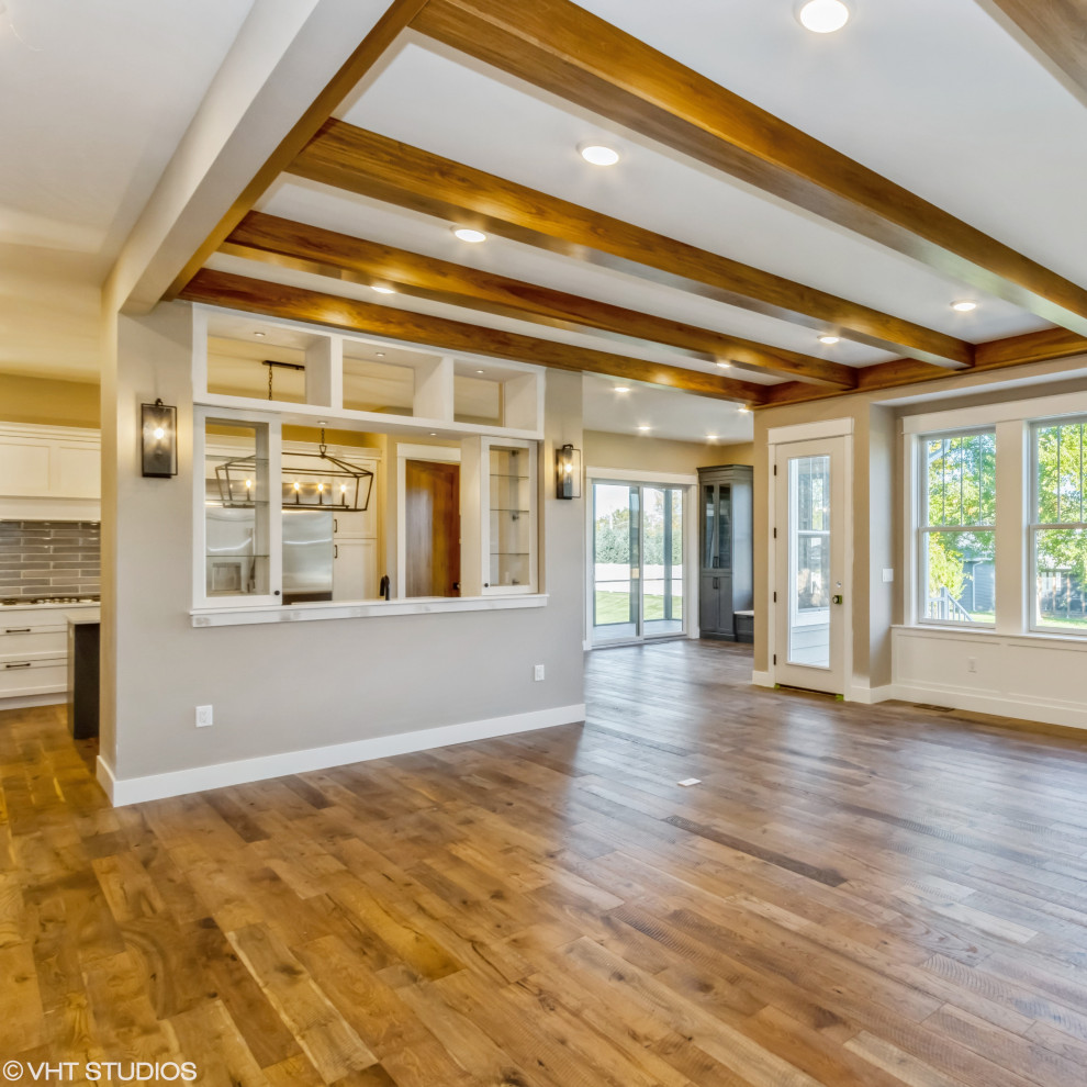 Foto de sala de estar de estilo de casa de campo grande con suelo de madera en tonos medios y vigas vistas