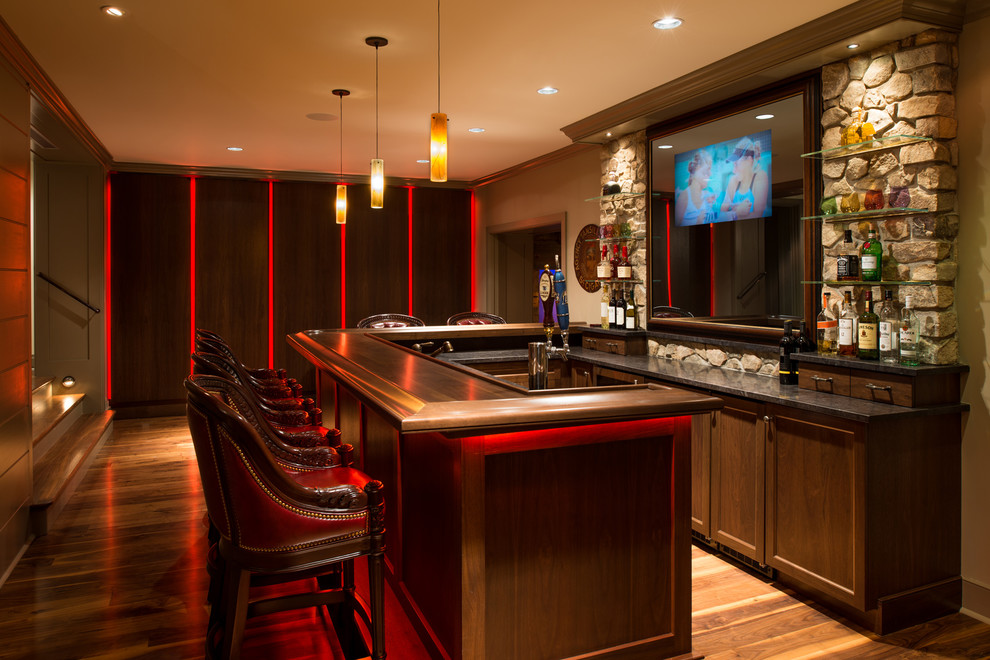 Design ideas for a large traditional l-shaped seated home bar in Philadelphia with an undermount sink, recessed-panel cabinets, wood benchtops, medium hardwood floors and brown benchtop.